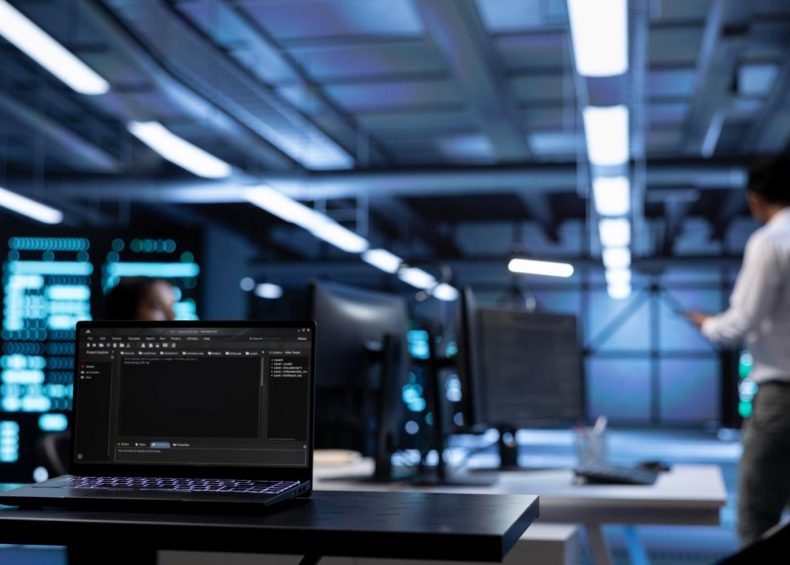 Estación de trabajo de consultoría software con laptop y monitores en ambiente tecnológico