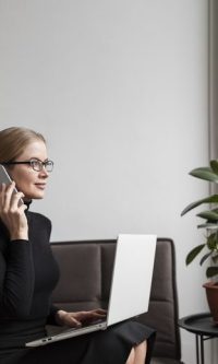 Gestora de proyectos software coordinando desarrollo mediante llamada y laptop