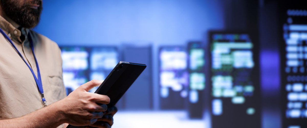 Experto utilizando una tablet en un centro de servidores, representando el desarrollo web integral de Elita Projects